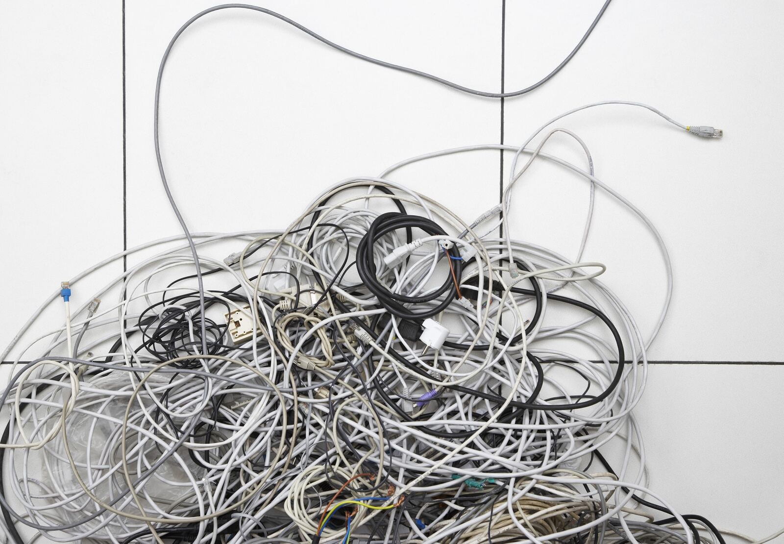 A pile of unlabelled and tangled network and electrical cables